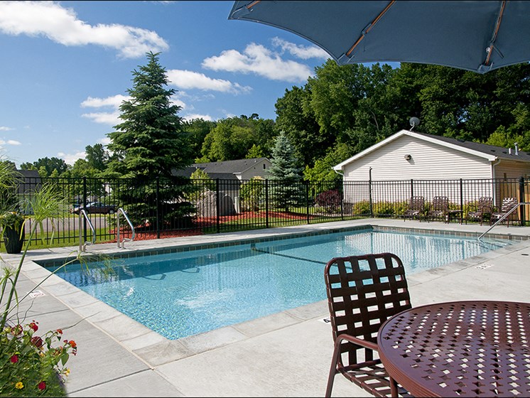 outdoor pool with deck chair and table with umbrella